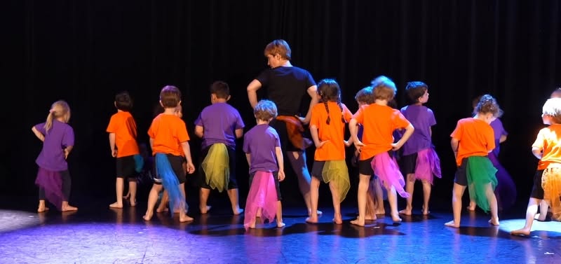 Groupe éveil cirque sur scène avec voiles colorés